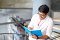 Hindu student boy or man reading book at library Royalty Free Stock Photo