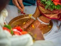 Closeup of decorated feet of an Indian bride while a traditional ritual performed during wedding