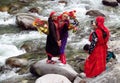 Young women in colorful clothes on a river bank wi