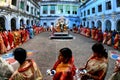 Hindu women walking around Durga Devi statue