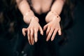 Hinged doll on a black background. Beautiful female hands closeup