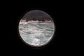 Hinged round window, storm cover on ship looking outside into Mediterranean sea. Porthole view through window on ship.