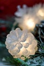 Hining white light cone garland and christmas tree branch on red bokeh background Royalty Free Stock Photo