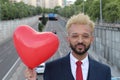 Hip Afro-Caribbean businessman holding heart balloon Royalty Free Stock Photo