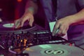 Hip hop DJ scratches vinyl records on turntables. Hands of disc jockey scratching record on turn table player in close up