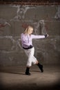 Hip hop girl dancing over grey brick wal Royalty Free Stock Photo