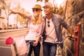 Hip young couple standing by brick wall with their bikes