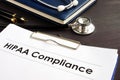 HIPAA Compliance documents with clipboard on a desk