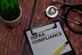 HIPAA Compliance write on paperwork isolated on wooden table