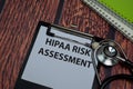 Hipaa Risk Assessment write on paperwork isolated on wooden table