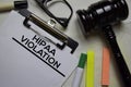 Hipaa Violation text on Document and gavel isolated on office desk.