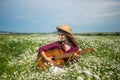 hippie. country music singer. woman in camomile field with acoustic guitar. Royalty Free Stock Photo