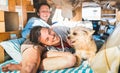 Hippie couple with funny dog traveling together on vintage minivan transport - Life inspiration concept with indie people on mini Royalty Free Stock Photo