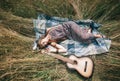 Hippie girl with guitar lying on the mowed grass Royalty Free Stock Photo