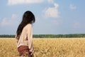 Hippie girl in wheat field rear view