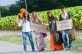 Hippie Group Hitchhiking on a Countryside Road Royalty Free Stock Photo