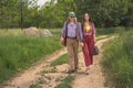 Hippie guy and girl, holding hands, walk along a country road Royalty Free Stock Photo