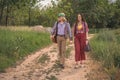 Hippie guy and girl, holding hands, walk along a country road Royalty Free Stock Photo