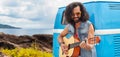 Hippie man playing guitar at minivan car on island