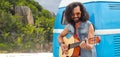 Hippie man playing guitar at minivan car on island