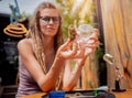 Hippie style woman examines under a magnifying glass the joints and buds of medical marijuana