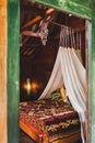 Hippie style wooden room with traditional bed, baldachin and dreamcatcher