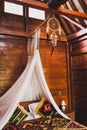 Hippie style wooden room with traditional bed, baldachin and dreamcatcher