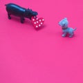 Hippo carries the heart in his mouth and gives it to the puppy on a pink background with copy space. Romantic scene Royalty Free Stock Photo