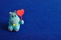 A hippo figurine holding a red heart