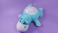 Hippo plushie toy isolated on purple background. Hippo plush stuffed puppet on purple backdrop.  Turquois hippo with starry sky. Royalty Free Stock Photo