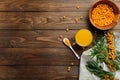 Hippophae juice, sea buckthorn berries on wooden table. Flat lay composition, top view. Natural organic autumn beverage