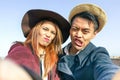 Hipster asian couple making selfie with funny faces - Lovers having fun together outdoor - Technology and fashion lifestyle Royalty Free Stock Photo