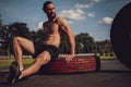 Hipster athlete resting on the tire afte workout Royalty Free Stock Photo
