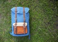 Hipster backpack on green grass. Summer travel prop. Outside trip gear. Packing bag for gap year journey
