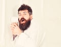 Hipster in bathrobe on shocked face secretly listen conversation. Secret and spy concept. Man with beard and mustache