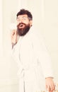 Hipster in bathrobe on surprised face secretly listen conversation. Secret and spy concept. Man with beard and mustache