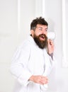 Hipster in bathrobe on surprised face secretly listen conversation. Secret and spy concept. Man in white interior spying Royalty Free Stock Photo
