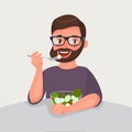 Hipster beard man is eating a salad. Vegetarian concept of healthy nutrition and lifestyle