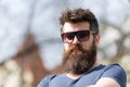 Hipster with beard and mustache on strict face, nature background, defocused. Bearded guy wears stylish sunglasses. Man Royalty Free Stock Photo