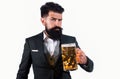 Hipster with beard and mustache in suit drinks beer after working day. Beer time. Handsome barman holding a big cup of Royalty Free Stock Photo