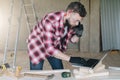 Hipster bearded man is carpenter, builder, designer stands in wo