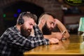 Hipster bearded man spend leisure at bar counter. Order drinks at bar counter. Men with headphones and smartphone Royalty Free Stock Photo