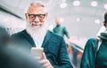 Hipster bearded man using mobile smart phone at shopping mall elevators - Trendy old person sharing content with smartphone Royalty Free Stock Photo