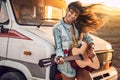 Hipster beautiful woman playing guitar with big smile on her face. Royalty Free Stock Photo