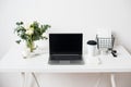 Hipster bloggers work place, laptop and flowers on white tabletop Royalty Free Stock Photo