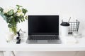 Hipster bloggers work place, laptop and flowers on white tabletop Royalty Free Stock Photo