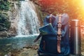 Hipster Blue Backpack, Map And Thermos Closeup. View From Front Tourist Traveler Bag On Waterfall Background. Adventure Hiking Con Royalty Free Stock Photo