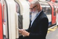 Hipster business senior man using mobile phone in subway station - Focus on face Royalty Free Stock Photo