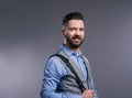 Hipster businessman in blue shirt, studio shot, gray background