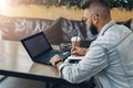 Hipster businessman sitting indoors,writing notes in notepad and working on laptop for solving working issues. Education